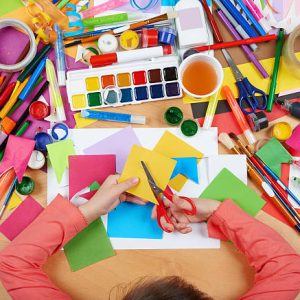 Child cut applique top view. Artwork workplace with creative accessories. Flat lay art tools for painting.
